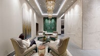 Located at 1909 Walnut Street in Philadelphia's prestigious Rittenhouse Square neighborhood, this elegantly designed lobby sets a striking first impression with its refined, contemporary aesthetic. The space is anchored by a towering emerald green geometric tile accent wall that commands immediate visual attention, complemented by large-format marble wall panels in creamy white tones with delicate veining. Underfoot, expansive grey stone-effect flooring stretches throughout, lending a sense of continuity and scale.

A cascading multi-tiered gold chandelier with crystal accents serves as a luminous centerpiece overhead, suspended within a recessed coffered ceiling detail that adds architectural depth. Recessed lighting throughout ensures the space is warmly and evenly illuminated.

The seating area features sophisticated gold wire-frame chairs and soft upholstered lounge seating arranged around glass and wood accent tables, creating an inviting yet polished atmosphere. Curated artwork adorns the walls, while fresh floral arrangements add organic warmth.

A gallery corridor lined with vibrant framed artwork and warm wood paneling, framed by sleek black-framed glass partitions, connects to adjacent areas. Near the elevator bank, a plush upholstered bench sits beside brushed metal elevator doors, with additional artwork providing a refined finishing touch throughout this distinguished space.
