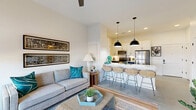 Located at 225 W Olney Rd in Norfolk, VA, this thoughtfully designed one-bedroom, one-bathroom residence offers a contemporary open-concept layout that maximizes both function and style. The combined kitchen and living area serves as the heart of the home, anchored by a striking kitchen island with a crisp white countertop, navy blue lower cabinetry, and woven rattan barstools. Dual black pendant lights hang overhead, complementing stainless steel appliances, white upper cabinetry, and a subway tile backsplash. The living area flows seamlessly from the kitchen and is bathed in natural light through expansive floor-to-ceiling glass doors that open to a private balcony, offering views of the surrounding Norfolk streetscape. A ceiling fan adds comfort to the airy space. The bedroom is generously proportioned, featuring its own floor-to-ceiling window wall that fills the room with light and outdoor views, alongside ample wall space for storage and media. The bathroom is clean and modern, with white cabinetry, a large vanity mirror, and a full tub-shower combination with matte black fixtures. Polished concrete flooring runs throughout, tying the contemporary aesthetic together cohesively.