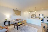 Located at 1551 Riverside Pkwy in Douglasville, GA, this well-designed one-bedroom, one-bathroom unit offers a thoughtful layout that maximizes its comfortable footprint. The open-concept living and kitchen area serves as the heart of the home, featuring light wood-style flooring, crisp white walls, and abundant natural light from large windows with views to the outdoors. The kitchen is outfitted with white shaker cabinetry, quartz countertops, a central island with a built-in sink and dishwasher, pendant lighting, and a full suite of stainless steel appliances including a refrigerator with ice maker, electric range, and over-the-range microwave. The living area flows naturally from the kitchen, offering a bright and open atmosphere with direct access to a private exterior door. The bedroom is carpeted for comfort, features a ceiling fan, and is illuminated by a large window that fills the room with natural light. The full bathroom maintains the unit's clean aesthetic with white subway tile in the tub/shower, a white vanity with quartz countertop, and wood-look tile flooring. A dedicated laundry area houses a full-size, top-load washer and dryer. A private closet and hall storage round out this efficiently designed, move-in-ready unit.