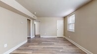 This compact yet well-designed apartment offers 530 square feet of efficient living space. The interior showcases a modern renovation with a cohesive neutral color palette throughout. The main living area boasts wood-look flooring, creating a warm and inviting atmosphere. Large windows in the living room and bedrooms allow ample natural light, enhancing the sense of space.

The kitchen, though compact, features updated cabinetry, a subway tile backsplash, and stainless steel appliances, including an electric range. The primary bedroom, measuring 140 square feet, offers carpeted flooring and dual windows with blinds for privacy. The second bedroom, also carpeted, provides additional living or sleeping space.

The bathroom, while not extensively shown, appears to have a white color scheme with modern fixtures. The apartment's layout includes a hallway and closet space, maximizing storage options. Overall, this residence combines contemporary design elements with practical features, making it an attractive option for those seeking a cozy yet stylish urban dwelling.