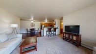Located on Heritage Drive in Marshfield, Wisconsin, this single-floor unit offers a practical and comfortable layout designed for everyday living. The open-concept main living area seamlessly connects the living room, dining area, and kitchen, creating a cohesive and functional space. The living room features neutral carpet, a ceiling fan, and room for generous seating arrangements, while hardwood-style flooring extends through the dining and kitchen areas.

The kitchen is well-appointed with warm honey-toned cabinetry, granite-look countertops, and a full suite of stainless steel appliances including a refrigerator, range, and microwave. A breakfast bar with barstool seating provides an additional casual dining option alongside the dedicated dining area, which comfortably accommodates a round table and chairs.

The bedroom offers a window with natural light and ample space, while the bathroom includes a walk-in shower, wood cabinetry with granite-style countertops, and hardwood-style flooring. A dedicated laundry room houses a full-size washer and dryer. Completing the unit is a spacious attached garage with an automatic opener, providing generous enclosed parking and additional storage space.