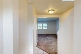 Located at 5854 NY-96 in Ovid, NY, this two-story, three-bedroom, three-bathroom home offers a practical and well-organized layout across two floors. The main level welcomes you through a tiled entrance that opens into a spacious carpeted living room, brightened by natural light from multiple windows and fitted with a ceiling fan. The galley-style kitchen features white cabinetry, dark countertops, a tile backsplash, tile flooring, and includes a refrigerator and electric range. A dedicated dining room, laundry area, and a half bathroom round out the first floor. Upstairs, three carpeted bedrooms provide comfortable living space, including a primary bedroom with vaulted ceilings, a ceiling fan, and a mirrored sliding-door closet. The additional bedrooms feature windows with natural light and generous closet space — with six closets distributed throughout the home in total. Two full bathrooms serve the upper level, one featuring a shower/tub combination with a window for ventilation. Textured ceilings, neutral wall tones, and tile flooring in wet areas give the home a clean, consistent aesthetic throughout.