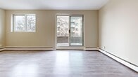 Located at 810 Exmouth St in Sarnia, Ontario, this one-bedroom unit offers a well-organized, efficiently designed layout across a single floor. The open-concept living and kitchen area forms the heart of the space, finished with light grey vinyl plank flooring that extends throughout the unit, creating a clean and cohesive aesthetic. Neutral warm-beige walls complement the bright, airy atmosphere.

The living area is generously proportioned, featuring a large sliding glass door that opens to a private balcony, allowing natural light to fill the room while providing views of the surrounding neighbourhood. Baseboard heaters run along the perimeter, ensuring consistent warmth throughout.

The kitchen is thoughtfully appointed with white cabinetry, dark granite-style countertops, a subway tile backsplash, and stainless steel appliances, including a range and refrigerator. A peninsula counter provides additional workspace and a casual dining option, seamlessly connecting the kitchen to the living space.

The bedroom is a comfortable size, featuring a large built-in closet with bifold doors and a window that brings in natural light. The unit also includes additional storage and a dedicated entryway. Overall, the space presents a clean, modern feel well-suited for everyday living.
