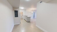 Located at 14981 SW 283 St in Homestead, FL, this single-story unit offers a clean, modern layout designed for comfortable living. The open-concept kitchen serves as the centerpiece of the main living area, featuring a peninsula with granite countertop and an integrated sink, light gray cabinetry, white appliances including a refrigerator, electric range, and microwave, and a walk-in pantry closet. A pendant light fixture above the peninsula adds a refined touch to the space.

The kitchen flows seamlessly into the living and dining areas, which are bathed in natural light from sliding glass doors fitted with vertical blinds. Light-toned large-format tile flooring extends throughout, creating a cohesive and airy feel. The living area provides direct outdoor access, enhancing the connection to natural light and ventilation.

The bedrooms are well-proportioned, each with the same light tile flooring and ample wall space. The electrical panel is conveniently integrated near the entry. The bathrooms are finished with granite-topped vanities, white cabinetry, large mirrors, and tub-shower combinations with tile surrounds. Clean white walls and recessed lighting throughout contribute to a bright, neutral palette that defines this well-appointed Homestead residence.
