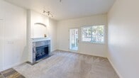 Located at 5014 88th Street Ct SW in Lakewood, Washington, this one-bedroom, one-bathroom unit offers a practical and comfortable single-floor layout. The living room serves as the centerpiece of the space, featuring a tile-surround fireplace with a built-in arched niche above the mantle, soft carpeted flooring, and a track lighting fixture. A glass exterior door alongside a large window floods the room with natural light and provides views of the surrounding greenery, while also offering convenient ground-floor outdoor access.

The galley-style kitchen is efficiently designed, featuring stainless steel appliances including a refrigerator and range, warm wood cabinetry, dark granite-style countertops, and light wood-look flooring. A peninsula counter provides a seamless transition between the kitchen and living area.

The bedroom is a well-proportioned, quiet retreat with two windows that bring in ample natural light. Soft carpeting, neutral walls, and a reach-in closet with built-in shelving provide functional storage. The full bathroom includes a tub/shower combination with accessibility grab bars, a wood-toned vanity with a dark countertop, and a mirrored medicine cabinet.