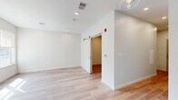 Located at 770 Water Street in Framingham, MA, this thoughtfully designed one-bedroom, one-bathroom residence offers a modern aesthetic with clean lines and quality finishes throughout. Light-toned hardwood-style flooring flows consistently across the entire space, creating a cohesive and bright atmosphere. The kitchen is a standout feature, equipped with stainless steel appliances including a French door refrigerator, electric range, microwave, and dishwasher. Soft white cabinetry with matte black hardware pairs with a classic subway tile backsplash and light countertops, while glass pendant lights add a contemporary touch overhead. A long hallway with recessed lighting connects the living areas to the private spaces. The bedroom is a well-proportioned retreat featuring a distinctive sliding barn door, recessed lighting, and direct access to a dedicated walk-in closet outfitted with wire shelving and hanging rods. The bathroom is finished with hexagonal tile flooring, a warm wood vanity with a white countertop, white overhead cabinetry, a large mirror, and a glass-enclosed walk-in shower with subway tile surround. The overall design is clean, modern, and move-in ready.