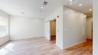 Located at 770 Water Street in Framingham, MA, this thoughtfully designed one-bedroom, one-bathroom residence offers a modern aesthetic with clean lines and quality finishes throughout. Light-toned hardwood-style flooring flows consistently across the entire space, creating a cohesive and bright atmosphere. The kitchen is a standout feature, equipped with stainless steel appliances including a French door refrigerator, electric range, microwave, and dishwasher. Soft white cabinetry with matte black hardware pairs with a classic subway tile backsplash and light countertops, while glass pendant lights add a contemporary touch overhead. A long hallway with recessed lighting connects the living areas to the private spaces. The bedroom is a well-proportioned retreat featuring a distinctive sliding barn door, recessed lighting, and direct access to a dedicated walk-in closet outfitted with wire shelving and hanging rods. The bathroom is finished with hexagonal tile flooring, a warm wood vanity with a white countertop, white overhead cabinetry, a large mirror, and a glass-enclosed walk-in shower with subway tile surround. The overall design is clean, modern, and move-in ready.