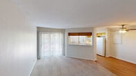 Located in Austin, TX, this 2-bedroom, 2-bathroom residence offers a well-organized single-floor layout designed for comfortable everyday living. The open living room is a welcoming centerpiece, featuring warm wood-style plank flooring, neutral-toned walls, and a textured ceiling that adds subtle character. Natural light flows in through vertical blind-covered sliding glass doors, brightening the generous living space. A ceiling fan adds a practical touch overhead.

The kitchen connects to the living area via a pass-through counter, creating an open, communicative feel between spaces. It is equipped with gray cabinetry, a refrigerator, a sink, recessed lighting, and two windows that bring in ample natural light, making it a bright and functional workspace.

Both bedrooms are comfortably sized and finished with plush carpeting, ceiling fans, and clean neutral walls, offering a quiet and restful atmosphere. The primary bedroom provides a well-proportioned retreat. A dedicated closet and hallway contribute to the unit's efficient use of space.

The two bathrooms are finished in a clean, classic style, each featuring a tiled shower-tub combo with brushed nickel fixtures, a toilet, and wood-style flooring, maintaining a cohesive and tidy aesthetic throughout the home.