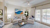 Located at 211 River Landing Drive in Charleston, SC, this well-appointed one-bedroom, one-bathroom residence offers a thoughtfully designed single-level layout with a bright, neutral palette throughout. The open-concept kitchen is a standout feature, showcasing white shaker cabinetry, granite countertops, a central island with seating, stainless steel appliances — including a French door refrigerator, electric range with microwave, and dishwasher — and a pendant chandelier that adds a touch of elegance. Light wood-look flooring flows through the main living areas, creating a cohesive and airy feel. The living room is warm and inviting, featuring a ceiling fan, generous natural light, and glass French doors that open to a private patio, seamlessly blending indoor and outdoor living. The bedroom is a serene retreat with plush carpeting, a ceiling fan, and its own set of French doors providing patio access and additional natural light. The full bathroom offers a tiled soaking tub and shower combo, granite vanity, and direct access to a dedicated walk-in closet. A distinctive exposed brick exterior facade, visible from the patio, adds charming architectural character to this polished Charleston residence.