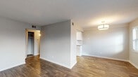 Located at 3015 Sprowl Rd in Louisville, Kentucky, this thoughtfully updated single-floor residence offers a clean, modern aesthetic throughout. The open living and dining areas are finished with rich, dark wood-style flooring and neutral gray walls, creating a bright and welcoming atmosphere. Multiple windows allow natural light to fill the space, complemented by contemporary flush-mount and pendant lighting fixtures.

The galley-style kitchen is well-appointed with white shaker cabinetry, granite countertops, a classic white subway tile backsplash, and black appliances including a range, microwave, and dishwasher — offering both style and functionality in an efficient layout.

The bedroom features soft carpeting, a ceiling fan with light, and a window with outdoor views, providing a comfortable and restful retreat. A dedicated closet offers generous storage.

The bathroom is finished with marble-look tile surrounding the tub and shower, a white vanity with granite countertops, and wood-style flooring, maintaining the cohesive design language found throughout the unit.

A hallway utility area houses a stacked washer and dryer unit, adding the convenience of in-unit laundry. The overall design reflects consistent, updated finishes that balance practicality with modern style.