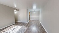 Located at 3400 Joyce Lane in Denton, TX, this 2-bedroom, 1-bathroom unit offers a practical and cohesive single-floor layout finished with consistent wood-look flooring throughout every room. The living room serves as the heart of the unit, featuring neutral gray walls, bright white trim and baseboards, and a large front-facing window that invites abundant natural light while a front entry door anchors the space. The open sightlines from the living area connect naturally to the hallway and the rest of the unit, creating an easy flow between rooms. The kitchen is efficiently arranged and includes a full-size refrigerator alongside ample cabinetry, keeping everything accessible and organized. Both bedrooms continue the neutral color palette with gray walls and wood-look flooring; the primary bedroom is a comfortable size and benefits from natural light through a window fitted with white blinds, while the second bedroom also features a window and two closet doors, providing notable storage flexibility. The bathroom is clean and functional, equipped with a full tub-shower combination. Throughout the unit, white panel doors, consistent trim work, and a unified color scheme of warm grays create a cohesive and move-in-ready atmosphere well-suited to comfortable everyday living.