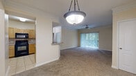 Located at 11212 Westpark Dr in Houston, TX, this single-floor, 3-bedroom, 3-bathroom home offers a well-designed layout with comfortable living spaces throughout. The open living and dining area features warm neutral tones, crown molding, plush carpeting, a ceiling fan, and a large sliding glass door that fills the space with natural light and provides outdoor views. A decorative pendant light adds a polished touch to the dining area.

The kitchen is efficiently designed with light wood cabinetry, granite-style countertops, tile flooring, and a full suite of black appliances including a refrigerator, electric range, dishwasher, and built-in microwave. A pass-through breakfast bar connects the kitchen to the living area, enhancing the open feel.

Each of the three bedrooms offers plush carpeting, a ceiling fan, and windows that bring in natural light and outdoor views. The spacious primary bedroom includes its own dedicated bathroom. The additional bedrooms are generously sized and share access to well-appointed bathrooms featuring tile flooring and tub/shower combinations.

Two closets provide ample storage, and an in-unit washer is visible within the layout. The home's consistent warm, neutral color palette and functional design create a comfortable and cohesive living environment throughout.