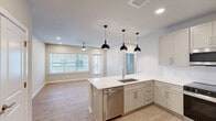 Located at 436 State Highway 30 in Port Wentworth, Georgia, this single-story 3-bedroom, 2-bathroom home offers a clean, modern aesthetic with consistent light-wood luxury vinyl flooring and neutral warm-beige walls throughout. The kitchen is a functional centerpiece, featuring shaker-style cabinetry in soft gray-white tones, white quartz countertops, stainless steel appliances including a range, over-the-range microwave, and a full-size refrigerator, all complemented by recessed lighting. Each of the three bedrooms is bright and airy, with ceiling fans, large windows fitted with horizontal blinds, and ample natural light. The spacious primary bedroom connects to a well-designed bathroom with an extended vanity, white quartz countertop, framed mirror, and wood-look flooring. A second full bathroom mirrors the same refined finishes. The walk-in closet includes wire shelving for organized storage. The entryway is practical and welcoming, offering double-door closet storage alongside direct unit access. A balcony extends the living space outdoors. The home's consistent design language — neutral tones, modern hardware, and durable finishes — creates a cohesive, move-in-ready living environment.