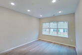 This contemporary apartment, part of The Lofts at Gloucester, offers a thoughtfully designed living space within 620 square feet. The open-concept layout seamlessly integrates the kitchen, living, and dining areas, creating a sense of spaciousness. The kitchen boasts dark wood cabinetry, stainless steel appliances, and a white subway tile backsplash, complemented by a convenient island with a sink.

The bedroom, measuring 170 square feet, features a large window allowing ample natural light and a glass door leading to a private outdoor space. Light-colored hardwood flooring runs throughout the apartment, enhancing the modern aesthetic. The bathroom showcases a sleek vanity with ample storage and a large mirror.

A notable feature is the in-unit laundry area with a stacked washer and dryer, tucked away yet easily accessible. Recessed lighting throughout provides adjustable illumination options. The neutral color palette of the walls allows for personalization while maintaining a clean, contemporary feel. This efficient floor plan maximizes the use of space, offering both style and functionality in an urban setting.