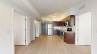 Located at 6161 Southern Blvd in West Palm Beach, Florida, this single-floor residence offers a clean, contemporary design with a cohesive aesthetic carried throughout every room. Light wood-style flooring runs continuously across the open-concept living and kitchen areas, creating a bright and airy atmosphere. The kitchen is a standout feature, outfitted with rich dark wood cabinetry extending to the ceiling for ample storage, granite-speckled countertops, a classic white subway tile backsplash, and a full suite of stainless steel appliances including a refrigerator, range, microwave, and dishwasher. Track lighting illuminates the kitchen and adjoining living area, which opens to the outdoors through a sliding glass door framed by lush greenery — allowing abundant natural light to pour in. The bedrooms are generously sized, finished in neutral tones with large windows dressed in horizontal blinds that offer views of the surrounding landscape. Each bathroom is well-appointed with granite vanity countertops, dark wood cabinetry, large-format tile surrounding the soaking tub and shower, and tile flooring. The overall ambiance is modern, clean, and move-in ready, reflecting thoughtful design suited for comfortable Florida living.