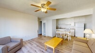 Located at 505 W Madison Ave in El Cajon, California, this single-floor, 3-bedroom, 1-bathroom residence offers a practical and efficient layout designed to maximize every inch of its space. The living room serves as the heart of the home, featuring light wood-style flooring, a ceiling fan with integrated lighting, a textured ceiling, and a wall-unit air conditioner. Natural light filters in through a front-facing window, and a door provides direct access to the exterior. The living area flows openly into the dining and kitchen space, creating a cohesive and functional common area. The kitchen is outfitted with white cabinetry, tan laminate countertops, a gas range, a full-size refrigerator, and a single-basin sink — all arranged in a compact, galley-style configuration. The three bedrooms are carpeted and simply appointed, each offering a quiet retreat with natural light from windows. The primary bedroom provides a comfortable footprint for essential furnishings. The bathroom features wood-style flooring, a white vanity with a tan countertop, and a tiled shower-tub combination with a curtain rod and grab bar for added convenience. Clean, neutral tones throughout the home create a bright and low-maintenance living environment.