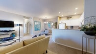 Located in Wichita, KS (67206), this 2-bedroom, 2-bathroom residence is thoughtfully arranged on a single floor, offering an efficient and comfortable layout. The open-concept living and dining area is anchored by plush carpeting and neutral tones, with the living room featuring large windows dressed in elegant drapes that invite natural light. A decorative chandelier illuminates the dining area, which is accented by a round mirror and vibrant teal artwork. The kitchen is equipped with white cabinetry, ample counter space, tile flooring, and a curved breakfast bar that connects seamlessly to the main living area. The primary bedroom is generously proportioned, featuring carpeted floors, a large closet, and an en-suite bathroom with a wide vanity, tile flooring, and a large mirror. The second bedroom also offers natural light through sizable windows. The second full bathroom conveniently includes an in-unit washer and dryer, adding practical functionality. Throughout the residence, a cohesive neutral palette with teal accents creates a calm and inviting ambiance, making this Wichita home a well-rounded and comfortable living space.