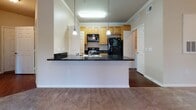 Located at 1840 Arden Creek Lane in Charlottesville, Virginia, this single-floor residence offers a well-organized layout with a variety of functional living spaces. The kitchen serves as a focal point, featuring light wood cabinetry that extends to the ceiling, dark granite countertops, and black appliances including a refrigerator, range, and built-in microwave. A peninsula with pendant lighting above provides an open connection to the adjacent living area, which is finished with hardwood-style flooring. Crown molding accents the kitchen and main living areas, adding a refined touch throughout.

The bedrooms are carpeted and generously proportioned, each benefiting from natural light through blinded windows. Several bedrooms include walk-in or reach-in closets, providing practical storage. The primary bedroom features a ceiling light fixture and direct access to an en-suite bathroom, while a separate bedroom connects to its own private bath as well.

The bathrooms are finished with large-format tile flooring and warm-toned wood vanities topped with light countertops and oversized mirrors. One bathroom includes a tiled shower enclosure. Neutral wall tones and consistent trim work create a cohesive aesthetic throughout the entire space.