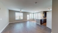 Located at 9200 Bruckhaus St in Raleigh, NC, this single-floor residence offers a thoughtfully designed open-concept layout with modern finishes throughout. The living area is bright and expansive, featuring wood-look flooring, a ceiling fan, and large windows with bay-style views that invite generous natural light and outdoor scenery. A sliding glass door provides access to a private balcony area.

The kitchen is a standout feature, showcasing dark wood cabinetry, granite-look countertops, a tile backsplash, and stainless steel appliances including a refrigerator and range. A peninsula with pendant lighting serves as both a functional workspace and a casual dining area, seamlessly connecting the kitchen to the living space.

The bedrooms are carpeted for comfort, each equipped with ceiling fans and ample window coverage offering neighborhood views. The primary bedroom includes a spacious walk-in closet outfitted with wire shelving and hanging rods.

The bathrooms are finished with wood-look flooring and granite-look countertops. The primary bath features a glass-enclosed walk-in shower and a single vanity, while the secondary bath includes a full soaking tub and shower combination. Additional storage closets are visible throughout, enhancing the overall functionality of this well-appointed home.