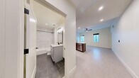 Located at 1813 Main in the heart of Columbia, SC, this thoughtfully designed residence offers three bedrooms and two full bathrooms across a single floor. The kitchen serves as a focal point, showcasing rich dark-stained cabinetry, white quartz countertops, a classic subway tile backsplash, and a full suite of stainless steel appliances. A peninsula island with a brass-toned faucet and globe pendant lights adds both function and style, opening seamlessly to the living area which features a ceiling fan and recessed lighting. The bedrooms are finished with neutral carpet and crisp white walls, creating bright, versatile spaces. Both bathrooms are appointed with striking dark slate-style tile flooring, marble-look tub and shower surrounds, white vanities with quartz countertops, and matte black fixtures throughout, delivering a clean, contemporary aesthetic. Recessed lighting and large mirrors enhance the sense of space in each bathroom. The clean, neutral palette and modern finishes found throughout the residence create a cohesive and polished living environment, well-suited for those seeking contemporary urban living in downtown Columbia.