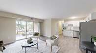 Located at 7101 Fernwood St in Henrico, Virginia, this well-appointed single-floor residence offers a thoughtfully designed layout encompassing a bedroom, bathroom, office, closet, and a combined kitchen and living area. Warm neutral tones and clean white trim flow consistently throughout the space, creating a cohesive and inviting ambiance.

The open-concept living room features wood-look hard flooring, large sliding glass doors that flood the space with natural light, and direct access to a covered balcony overlooking a landscaped setting with mature pine trees. The kitchen is well-equipped with white shaker cabinetry, a classic subway tile backsplash, stone-look countertops, and a full suite of stainless steel appliances, including a dishwasher, range, microwave, and refrigerator.

The spacious primary bedroom is carpeted for comfort, features a large window with views of the surrounding greenery, and provides access to a dedicated closet and full bathroom. The bathroom includes a white vanity with a wide mirror. A separate office space, also carpeted and naturally lit, offers a quiet and versatile area suitable for work or study. This residence combines practical functionality with a clean, modern aesthetic throughout.