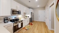 Located at University Executive Park in Charlotte, NC, this one-bedroom, one-bathroom unit is thoughtfully designed to maximize its compact footprint. Light wood-tone flooring flows consistently throughout, creating a cohesive and airy feel across the single-level layout.

The kitchen is a standout feature, outfitted with crisp white shaker cabinetry extending to the ceiling for ample storage, a neutral tile backsplash, white quartz countertops, and a full suite of stainless steel appliances including a range, microwave, dishwasher, and refrigerator. A breakfast bar provides a casual dining surface, adding both function and openness to the space.

The bedroom is a comfortable retreat, benefiting from natural light through a large window with blinds and recessed lighting overhead. A dedicated closet offers practical storage solutions.

The bathroom is clean and modern, featuring a white vanity with ample counter space, a tub/shower combination with large-format white tile surround, and light wood flooring that ties into the rest of the unit.

A stacked in-unit washer and dryer is conveniently located in its own closet, adding everyday practicality. Recessed lighting and neutral warm-beige walls throughout lend the space a bright, welcoming ambiance.