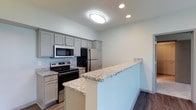 Located at 2828 Marblevista Blvd in Columbus, Ohio, this single-floor residence offers a clean, modern aesthetic throughout its thoughtfully designed layout. The kitchen serves as a standout feature, showcasing gray shaker-style cabinetry that provides ample storage, complemented by granite-style countertops that add a touch of elegance. A peninsula counter extends the workspace and creates a natural division between the kitchen and the adjacent living area, making it ideal for casual dining or entertaining. The kitchen is equipped with a full suite of stainless steel appliances, including a refrigerator, electric range, and over-the-range microwave, combining style with functionality. Recessed lighting and a central flush-mount ceiling fixture ensure the space is well-lit, while the dark hardwood-style flooring provides a warm contrast to the light-toned walls and cabinetry. The overall color palette of soft whites and grays creates a bright, neutral ambiance that feels both contemporary and welcoming. The single-floor layout offers convenience and accessibility, making this residence a practical and stylish option in the Columbus, OH area.