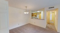 This single-floor, 3-bedroom, 2-bathroom residence offers a practical and comfortable layout designed for everyday living. The living and dining area is carpeted and features a decorative chandelier, textured ceiling, and a sliding glass door that floods the space with natural light while providing direct access to an outdoor area. A ceiling fan overhead enhances air circulation throughout the room.

The kitchen is positioned adjacent to the dining area, connected via an open pass-through counter that promotes a sense of openness. It is equipped with warm-toned wood cabinetry, a double-basin sink, a dishwasher, and an electric range, all set atop light tile flooring.

The bedrooms are carpeted and well-sized, with the primary bedroom featuring dual bifold closets offering generous storage. Additional bedrooms include natural light from window with blinds. A carpeted hallway connects the bedrooms to both bathrooms, each featuring a tub-shower combination, tile flooring, and a wood-vanity with a speckled countertop.

A notable convenience is the in-unit laundry closet, tucked discreetly in the hallway and housing a full-sized washer and dryer. The overall aesthetic is clean and neutral throughout.