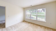 Located at 2350 Carlyle Place Dr in Winston-Salem, NC, this single-floor unit offers a straightforward and functional layout designed for comfortable everyday living. The open living area features neutral-toned carpet and a tiled entryway, providing a clean and welcoming entry point. A six-panel front door opens into the spacious main living space, which benefits from ample natural light and a practical HVAC vent system.

The kitchen is efficiently designed with light wood cabinetry, white appliances including an electric range and refrigerator, a double-basin stainless steel sink, and durable tile flooring in a warm earth tone. The layout allows for easy movement and functional meal preparation.

The bedrooms are carpeted and finished with neutral walls, offering a calm atmosphere. One bedroom features a wide bank of windows that overlooks a green outdoor area, allowing generous natural light to fill the room, while a second bedroom includes a single window with outdoor views as well.

The bathroom is equipped with tile flooring matching the kitchen, a towel bar, toilet, and vanity with countertop. The space is clean and utilitarian in design. Throughout the unit, the consistent use of neutral tones, natural light, and practical finishes creates a cohesive and move-in ready environment.