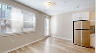Located at 2824 N Federal Blvd in Denver, Colorado's Sunnyside neighborhood, this single-floor unit offers a thoughtfully arranged layout that makes efficient use of its space. Light-toned hardwood-style flooring runs throughout, lending warmth and visual continuity to each area.

The open living and kitchen area forms the heart of the unit. The kitchen features white cabinetry, stainless steel appliances including a refrigerator, range, and microwave, and is seamlessly connected to the living space. Natural light enters through multiple windows fitted with blinds, brightening the neutral-toned walls and creating an airy atmosphere. A door from the living area provides additional access to the exterior.

The bedroom is a quiet, simply finished room with light walls and a window that allows natural light to filter in. A wardrobe with a mirrored panel provides practical storage within the space.

A hallway connects the main living areas to the bathroom, which is cleanly finished with a granite-topped vanity, a walk-in shower with white tile surround and granite base, and wood-style flooring consistent with the rest of the unit. Chrome fixtures and grab bars add functional detail throughout.

The overall design is clean and contemporary, with a neutral color palette and modern finishes that create a cohesive, move-in-ready environment.