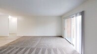 Located at 425 Waupelani Dr. in State College, PA, this single-floor unit offers 690 square feet of thoughtfully utilized living space. The layout encompasses a combined kitchen and living area, along with additional carpeted rooms that provide flexible living arrangements. The kitchen is equipped with stainless steel appliances, including a full-size refrigerator and dishwasher, complemented by dark cabinetry and light wood-look flooring that creates a clean, modern contrast. The living area features neutral-toned carpeting and crisp white walls, lending a bright and open feel to the space. A sliding glass door floods the living area with natural light and offers a view of the exterior brick surroundings, while additional windows in the carpeted rooms provide further ventilation and daylight. Closet storage is accessible directly from the main carpeted room, adding practical functionality. The unit's straightforward, efficient floor plan, as visible in the dollhouse overview, includes a bathroom and connecting hallways that keep the space organized and easy to navigate. With its neutral finishes and functional design, this unit offers a clean canvas well-suited for comfortable everyday living.