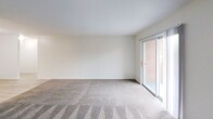 Located at 425 Waupelani Dr. in State College, PA, this single-floor unit offers 690 square feet of thoughtfully utilized living space. The layout encompasses a combined kitchen and living area, along with additional carpeted rooms that provide flexible living arrangements. The kitchen is equipped with stainless steel appliances, including a full-size refrigerator and dishwasher, complemented by dark cabinetry and light wood-look flooring that creates a clean, modern contrast. The living area features neutral-toned carpeting and crisp white walls, lending a bright and open feel to the space. A sliding glass door floods the living area with natural light and offers a view of the exterior brick surroundings, while additional windows in the carpeted rooms provide further ventilation and daylight. Closet storage is accessible directly from the main carpeted room, adding practical functionality. The unit's straightforward, efficient floor plan, as visible in the dollhouse overview, includes a bathroom and connecting hallways that keep the space organized and easy to navigate. With its neutral finishes and functional design, this unit offers a clean canvas well-suited for comfortable everyday living.