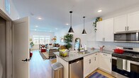 Located at 1000 Samuel Peterson Dr in Titusville, NJ, this well-appointed one-bedroom, one-bathroom residence offers a thoughtfully designed open-concept floor plan. The combined kitchen, dining, and living area forms the heart of the home, showcasing warm luxury vinyl plank flooring, crisp white walls, and recessed lighting throughout. The modern kitchen is equipped with stainless steel appliances including a French door refrigerator, gas range, built-in microwave, and dishwasher. White shaker cabinets, a herringbone tile backsplash, and granite countertops lend a clean, polished aesthetic, while a peninsula with seating provides an ideal casual dining spot. Pendant lights add a stylish focal point above. The adjacent living and dining areas are bright and airy, benefiting from large windows that invite natural light. A private balcony extends the living space outdoors. The spacious bedroom features plush carpeting, a ceiling fan, a generous closet, and a large window with outdoor views. The full bathroom features classic black-and-white hexagon tile flooring, a wood-tone vanity with dark countertop, and black fixtures. Two closets, a dedicated laundry area, and additional storage round out this efficiently designed and elegantly finished residence.