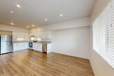 Located at 8500 Old Redwood Hwy in Windsor, CA, this 2-bedroom, 1-bathroom single-floor residence offers a clean, modern design with a thoughtful layout. The open-concept living area seamlessly integrates the kitchen, dining, and living spaces, creating a bright and functional environment. The kitchen is well-appointed with white shaker-style cabinetry, granite countertops, and a full suite of stainless steel appliances including a refrigerator, range, dishwasher, and range hood. Recessed lighting illuminates the space, while wood-style flooring flows consistently throughout the home, adding warmth and visual continuity. The living area benefits from natural light through multiple windows fitted with blinds, and a glass door provides additional light and outdoor access. Both bedrooms are comfortably sized, each featuring a window with outdoor views and ample closet space — the home includes five closets in total. The bathroom is finished with a white vanity, large mirror with overhead lighting, and matching wood-style flooring. Neutral wall tones and clean lines throughout contribute to a fresh, move-in ready aesthetic. A hallway connects the private sleeping quarters to the main living spaces, ensuring a practical and well-organized floor plan.