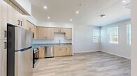 Located at 580 Media Pl in Sacramento, CA, this two-bedroom, two-bathroom residence offers a thoughtfully designed single-floor layout with a clean, contemporary aesthetic throughout. The open-concept kitchen is a standout feature, showcasing light wood cabinetry, granite countertops, a mosaic tile backsplash, and a full suite of stainless steel appliances including a refrigerator, range, microwave, and dishwasher. Recessed lighting and light wood-look flooring add to the bright, modern feel of the kitchen and living areas. Both bedrooms are carpeted for comfort and warmth, each featuring neutral tones, natural light through horizontal-blind windows, sliding panel closets, and wall-mounted mini-split HVAC units for individual climate control. The two bathrooms mirror the home's consistent design language, with light wood vanities, granite countertops, tub-shower combinations with tiled surrounds, and light wood-look flooring. A connecting hallway ties the layout together efficiently. The overall ambiance is clean, modern, and move-in ready, with cohesive finishes throughout that create a comfortable and functional living space.
