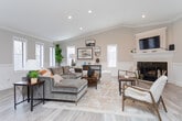 Located at 201 Wind Rd in Greensboro, NC, this single-floor space offers a well-appointed layout designed for both comfort and functionality. Throughout, light hardwood flooring, neutral warm-toned walls, and elegant crown molding with wainscoting paneling create a cohesive, refined aesthetic.

The lounge area is a standout feature, showcasing vaulted ceilings, recessed lighting, and a fireplace that serves as a natural focal point. Multiple windows fitted with white plantation shutters flood the room with natural light, enhancing the open and airy feel. Tasteful furnishings, including a plush sectional sofa and classic accent chairs, complement the space's welcoming character.

The open dining area accommodates a large rectangular wood table with ample seating, ideal for gatherings or meetings. French doors along one wall provide direct access to an outdoor area and allow generous natural light to pour in, reinforcing the connection between interior and exterior.

A compact kitchenette supports the space with white cabinetry, a stainless steel refrigerator, a sink, and a mobile prep station — providing convenient amenities without occupying significant floor area.

Together, these areas form a versatile, well-lit space suited for community use, offering a balance of practical function and inviting design.