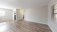 Located at 1701 E 131st Ave in Tampa, Florida, this single-story, one-bedroom, one-bathroom home offers a practical and well-organized layout. Wood-look plank flooring runs consistently throughout the space, providing a cohesive and easy-to-maintain finish that ties each room together.

The living room is open and airy, featuring neutral-toned walls, natural light from multiple windows, and a wall-mounted air conditioning unit. The clean lines and light color palette create a bright, welcoming atmosphere. The layout allows for a clear sightline into the kitchen, enhancing the sense of openness.

The kitchen is a functional galley-style space equipped with white cabinetry, light countertops, a double-basin sink, and black appliances including an electric range, range hood, and full-size refrigerator. A window above the sink allows natural light to brighten the workspace.

The bedroom is generously sized, featuring warm neutral walls, wood-look flooring, a window for natural light, and a large sliding-door closet that provides ample storage space.

The bathroom is finished in a clean, all-white aesthetic with a single-sink vanity, a shower/tub combo with a curved curtain rod, and a window that allows natural ventilation and light. The wood-look flooring continues into this space, maintaining design consistency throughout the home.