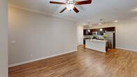 Located at 5221 Old Hixson Pike in Chattanooga, TN, this two-bedroom, two-bathroom residence offers a well-designed single-floor layout with a clean, modern aesthetic throughout. The open-concept living and kitchen area serves as the heart of the home, featuring warm hardwood-style flooring, crown molding, and a ceiling fan with light fixture. The kitchen is a standout, equipped with rich dark espresso cabinetry reaching to the ceiling, granite countertops, a subway tile backsplash, stainless steel appliances, and a peninsula island with a double sink and pendant lighting — ideal for both cooking and casual dining. The spacious primary bedroom is carpeted for comfort, bathed in natural light from large windows, and includes a ceiling fan and a double-door closet. The second bedroom also features hardwood-style flooring, crown molding, and a window for natural light. Both bathrooms are well-appointed with granite vanities and tub-shower combinations. Additional closets provide ample storage throughout. The neutral color palette and consistent finishes create a cohesive, inviting ambiance across all rooms.