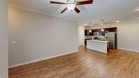 Located at 5221 Old Hixson Pike in Chattanooga, TN, this two-bedroom, two-bathroom residence offers a well-designed single-floor layout with a clean, modern aesthetic throughout. The open-concept living and kitchen area serves as the heart of the home, featuring warm hardwood-style flooring, crown molding, and a ceiling fan with light fixture. The kitchen is a standout, equipped with rich dark espresso cabinetry reaching to the ceiling, granite countertops, a subway tile backsplash, stainless steel appliances, and a peninsula island with a double sink and pendant lighting — ideal for both cooking and casual dining. The spacious primary bedroom is carpeted for comfort, bathed in natural light from large windows, and includes a ceiling fan and a double-door closet. The second bedroom also features hardwood-style flooring, crown molding, and a window for natural light. Both bathrooms are well-appointed with granite vanities and tub-shower combinations. Additional closets provide ample storage throughout. The neutral color palette and consistent finishes create a cohesive, inviting ambiance across all rooms.