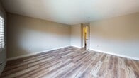 Located at 19143 Victory Blvd in Reseda, CA, this thoughtfully updated single-floor unit showcases a clean, modern aesthetic with quality finishes throughout. The open living area greets you with light-toned luxury vinyl plank flooring, neutral warm-beige walls, and a textured ceiling, creating a bright and welcoming atmosphere. A ceiling fan adds comfort to the living space, which flows seamlessly toward the kitchen. The kitchen is well-appointed with charcoal gray cabinetry, light quartz countertops, a classic subway tile backsplash, a double-basin sink with a matte black faucet, and stainless steel appliances including a range and over-the-range microwave. A window with shutters allows natural light to brighten the cooking space. The bedrooms feature plush carpeting, ceiling fans with integrated lighting, and shuttered windows that offer pleasant outdoor views. Each bedroom provides a calm, comfortable retreat. The bathroom is finished with gray cabinetry, a quartz vanity top, a large wall mirror, and a tub/shower combination enclosed by sleek sliding glass doors with dark-framed accents. Light vinyl flooring ties the bathroom together with a clean, contemporary look. Overall, the unit presents a cohesive, move-in-ready environment with updated details throughout.