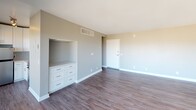 Located at 415 Washington Blvd in Marina del Rey, Los Angeles, this single-floor unit offers a thoughtfully designed layout with clean finishes throughout. The open living area is a standout feature, centered around large sliding glass doors that lead to a balcony and frame sweeping panoramic views of the city skyline and surrounding mountains. Rich, dark hardwood-style flooring runs throughout the main living space, complementing the neutral gray and warm beige wall tones for a modern yet inviting atmosphere. A built-in white dresser with ample drawer storage is seamlessly integrated into the living area wall, adding both functionality and a polished aesthetic. The kitchen is efficiently designed, featuring crisp white cabinetry, light quartz-style countertops, a stainless steel undermount sink, a stainless steel range with oven, a mounted microwave, and a soft blue subway tile backsplash that adds a subtle coastal charm. The bathroom is clean and functional, finished with wood-look flooring, neutral gray walls, and a tub-shower combination. Natural light flows generously through the space, enhancing the airy and open feel. This unit offers a well-balanced blend of practicality and style in a prime Los Angeles coastal location.