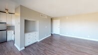 Located at 415 Washington Blvd in Marina del Rey, Los Angeles, this single-floor unit offers a thoughtfully designed layout with clean finishes throughout. The open living area is a standout feature, centered around large sliding glass doors that lead to a balcony and frame sweeping panoramic views of the city skyline and surrounding mountains. Rich, dark hardwood-style flooring runs throughout the main living space, complementing the neutral gray and warm beige wall tones for a modern yet inviting atmosphere. A built-in white dresser with ample drawer storage is seamlessly integrated into the living area wall, adding both functionality and a polished aesthetic. The kitchen is efficiently designed, featuring crisp white cabinetry, light quartz-style countertops, a stainless steel undermount sink, a stainless steel range with oven, a mounted microwave, and a soft blue subway tile backsplash that adds a subtle coastal charm. The bathroom is clean and functional, finished with wood-look flooring, neutral gray walls, and a tub-shower combination. Natural light flows generously through the space, enhancing the airy and open feel. This unit offers a well-balanced blend of practicality and style in a prime Los Angeles coastal location.