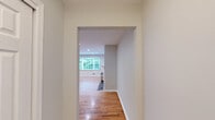This well-appointed single-floor residence in Morristown, NJ offers three bedrooms, two bathrooms, and a thoughtfully arranged layout across a comfortable footprint. Warm-toned hardwood flooring flows consistently throughout the living areas and bedrooms, lending the home a cohesive and inviting character.

The living room serves as a focal point, featuring a classic wood-burning fireplace with a painted brick surround and white mantel. Recessed lighting and a large window frame lush greenery views, filling the space with natural light. An adjacent area provides additional room for flexible use and connects smoothly to the rest of the home.

The kitchen is equipped with rich, dark-stained wood cabinetry — both upper and lower — paired with clean white countertops that offer generous workspace and ample storage.

The spacious primary bedroom benefits from natural light through a window overlooking greenery. The additional bedrooms each feature dual windows with views of mature trees, hardwood floors, and neutral walls, creating bright, functional spaces.

The two bathrooms are clean and practical. One features tile flooring, a dark wood vanity with a white countertop, a medicine cabinet mirror, and elegant dual-sconce lighting. The second bathroom offers a wide wood vanity with tile flooring and a large mirror.

Overall, the home presents a clean, neutral palette with consistent finishes throughout.