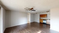 Located at 8500 S 28th St in Fort Smith, Arkansas, this 2-bedroom, 2-bathroom residence offers a functional and well-organized single-floor layout. The open-concept living and kitchen area serves as the heart of the home, featuring durable hardwood-style flooring, a ceiling fan with light fixture, and a sliding glass door that fills the space with natural light and provides direct access to a private balcony overlooking a landscaped courtyard with mature trees. The kitchen is well-equipped with abundant warm-toned wood cabinetry, ample counter space, a double sink, a dishwasher, a range, and a refrigerator, along with a dedicated pantry for additional storage. Both bedrooms are carpeted for comfort and include windows that bring in natural light, with four closets distributed throughout the unit for generous storage. The two full bathrooms each feature a tiled tub-shower combination, a wood-vanity with sink, and hardwood-style flooring. Additional spaces include a utility room, hallway, and multiple closets. Textured ceilings are consistent throughout the home, contributing to its classic residential character.