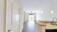 Located at 4565 Ponce de Leon Blvd in the heart of Coral Gables, Florida, this well-appointed 2-bedroom, 1-bathroom residence offers a functional and modern layout across a single floor. The open-concept living and kitchen area forms the central hub of the space, featuring wood-look flooring throughout and a seamless flow between rooms. The kitchen is equipped with rich dark-wood cabinetry, granite countertops, a mosaic tile backsplash, and a full suite of stainless steel appliances including a refrigerator, range, and built-in microwave. A peninsula with pendant lighting and track lighting overhead adds both style and practicality. The living area extends to a private balcony through sliding glass doors, where a ceiling fan and open city views enhance the space. Both bedrooms are bright and well-sized, with light-toned walls and wood-look flooring. The primary bedroom benefits from natural light through large sliding windows with urban views. A dedicated walk-in closet with wire shelving provides ample storage. The bathroom features large-format tile flooring, a dark-wood vanity with quartz countertop, a framed mirror, and a tub-shower combination.
