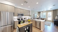 Located at 25400 North 21st Avenue in Phoenix, AZ, this single-floor, one-bedroom, one-bathroom residence offers a thoughtfully designed layout that maximizes every square foot of its compact footprint. The open-concept kitchen is a standout feature, boasting light wood-tone cabinetry that reaches the ceiling for ample storage, white quartz countertops, a full suite of stainless steel appliances including a French door refrigerator, electric range, built-in microwave, and dishwasher, all set over light hardwood-style flooring. A freestanding island with a butcher block top adds additional prep and storage space.

The living room is bright and inviting, with large windows and glass doors that flood the space with natural light and provide access to an outdoor area. A ceiling fan enhances comfort throughout the year.

The bedroom is a comfortable retreat, featuring plush carpeting, a large window with outdoor views, and a dedicated walk-in closet equipped with built-in shelving, hanging rods, and organizational drawers.

The bathroom is clean and modern, featuring light wood-tone vanity cabinetry, a white countertop, a glass-enclosed shower, and wood-look tile flooring. A hallway connects all rooms, contributing to the efficient and functional flow of this well-designed residence.