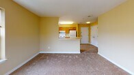 Located at 697 Ferry Ave in Camden, New Jersey, this single-floor residence offers a well-organized and functional layout designed for comfortable everyday living. The warm, golden-yellow walls throughout create a cohesive and inviting atmosphere across all rooms.

The open-concept living area is generously sized, featuring soft carpeted flooring and seamless sight lines to the kitchen. The kitchen is thoughtfully arranged in a U-shaped configuration, outfitted with warm wood cabinetry, ample counter space, white appliances including a dishwasher, electric range, and refrigerator, and a window that invites natural light. A breakfast bar with a rounded countertop edge connects the kitchen to the living area, enhancing the open feel.

The residence includes multiple bedrooms, each carpeted and bathed in natural light through double-pane windows with blinds, offering views of the surrounding neighborhood. The rooms provide ample space for furnishing and personal use.

The bathroom is equipped with a full soaking tub and shower combination featuring grab bars for accessibility, a wood-vanity with a white countertop, a wall-mounted mirror with overhead lighting, and clean white tile flooring. A closet and entry area complete the layout, making this a practical and well-appointed single-level home.