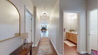 Located in Eden Prairie, Minnesota, this well-appointed 2-bedroom, 3-bathroom single-floor residence offers a thoughtfully designed layout with a comfortable and functional flow throughout. Rich hardwood flooring runs through the main living areas, complemented by neutral wall tones and textured ceilings that lend a warm, welcoming ambiance.

The kitchen is a standout feature, showcasing light maple cabinetry, stainless steel appliances, pendant lighting, and a curved breakfast bar island that connects seamlessly to the living and dining areas. The adjacent dining space is intimate and well-lit, with wall sconce lighting adding a refined touch.

The living room is bathed in natural light from large corner windows that frame lush, tree-lined outdoor views, creating a bright and inviting retreat. Both bedrooms are carpeted for comfort—the generously sized primary suite features vaulted ceilings and a private bath, while the second bedroom also enjoys serene wooded views through a large window.

Three bathrooms serve the home, including a shared bath with warm maple vanity cabinetry, a white countertop, and hardwood flooring. A dedicated in-unit laundry room adds everyday convenience. A wide entry hallway with elegant runner lighting ties the entire floor plan together with ease and style.