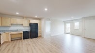 This well-appointed 3-bedroom, 2-bathroom residence in Kasson, Minnesota offers a thoughtfully designed single-floor layout with a clean, modern aesthetic throughout. Light wood-style flooring runs seamlessly across the entire space, complementing the neutral white walls and creating a bright, cohesive atmosphere.

The open-concept kitchen and living area serves as the heart of the home. The kitchen is equipped with light maple cabinetry, granite-style countertops, black appliances including a full-size refrigerator, range, and dishwasher, and recessed lighting overhead. The adjacent living area is generously sized and features a glass door leading to a private balcony with outdoor views of the surrounding landscape.

The primary bedroom is a comfortable, well-lit room with a large window framing scenic outdoor views. Two additional bedrooms provide flexible space for various needs. The residence includes two bathrooms: one full bath featuring a walk-in shower with grab bars, a granite-topped vanity with maple cabinetry, and the second bathroom offering a similarly finished vanity. Four closets throughout provide exceptional storage, while a dedicated in-unit laundry room and utility room add everyday convenience. Hallways are clean and open, enhancing the overall sense of space.