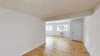 Located at 1000 Oaks Drive in Atlantic Highlands, NJ, this well-appointed one-bedroom, one-bathroom unit offers a clean, modern aesthetic across a thoughtfully designed single-floor layout. Light-toned hardwood floors run throughout the main living areas, lending warmth and continuity to the space.

The expansive living room is bright and open, featuring multiple windows that invite generous natural light and views of the surrounding greenery. Baseboard heating and a wall-mounted A/C unit ensure year-round comfort. The room flows seamlessly toward the entry door, creating an airy, welcoming atmosphere.

The kitchen stands out with its refreshed design, showcasing sage-green shaker-style cabinetry accented by gold hardware, white quartz countertops, a clean tile backsplash, and a full suite of stainless steel appliances including a range, microwave, refrigerator, and dishwasher. Light tile flooring ties the space together neatly.

The spacious primary bedroom features two double sliding-door closets, providing ample storage, along with natural light from a window overlooking the exterior. A dedicated utility room accommodates in-unit laundry.

The bathroom is tastefully updated with a sage vanity, gold hardware, a framed mirror, and a full tub-shower combination, maintaining the cohesive color palette found throughout the home.